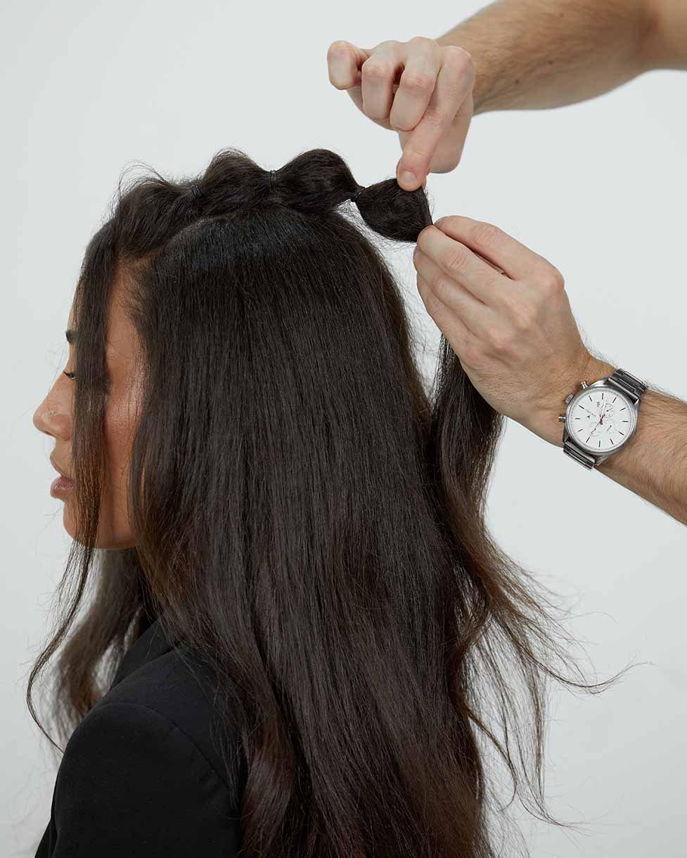 Stylist weitet Bubble Braids mit den Händen