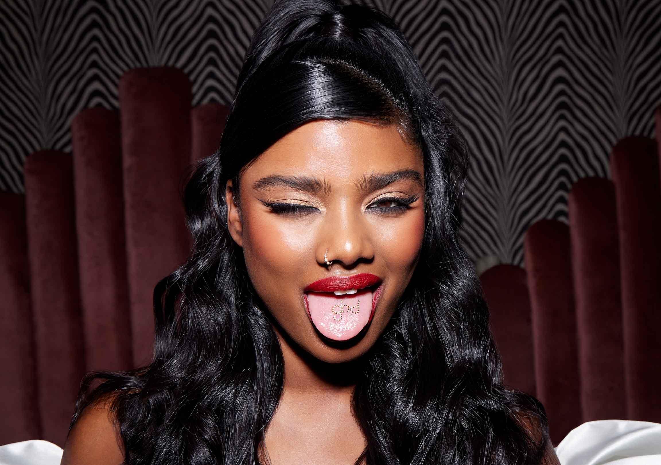 Model mit ghd Logo auf der Zunge