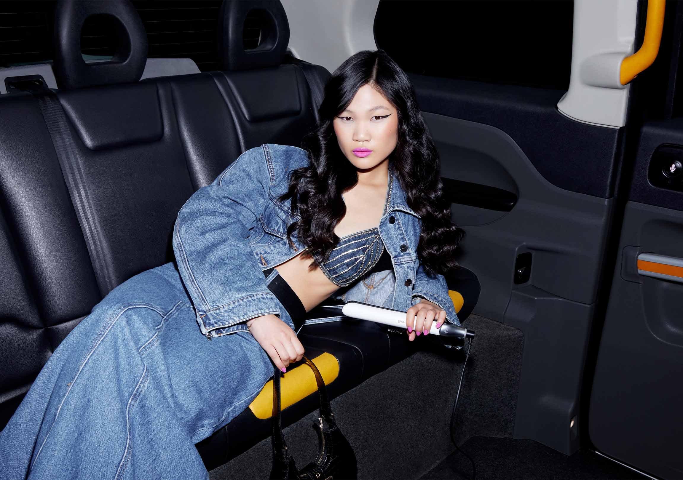 Model im Taxi mit ghd chronos Glätteisen