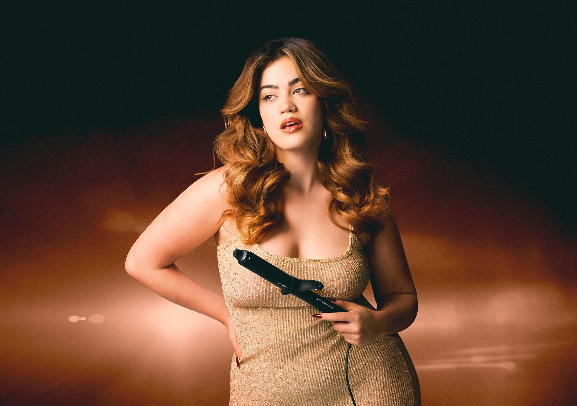 Model mit voluminösen Locken präsentiert den ghd chronos curve grand tong