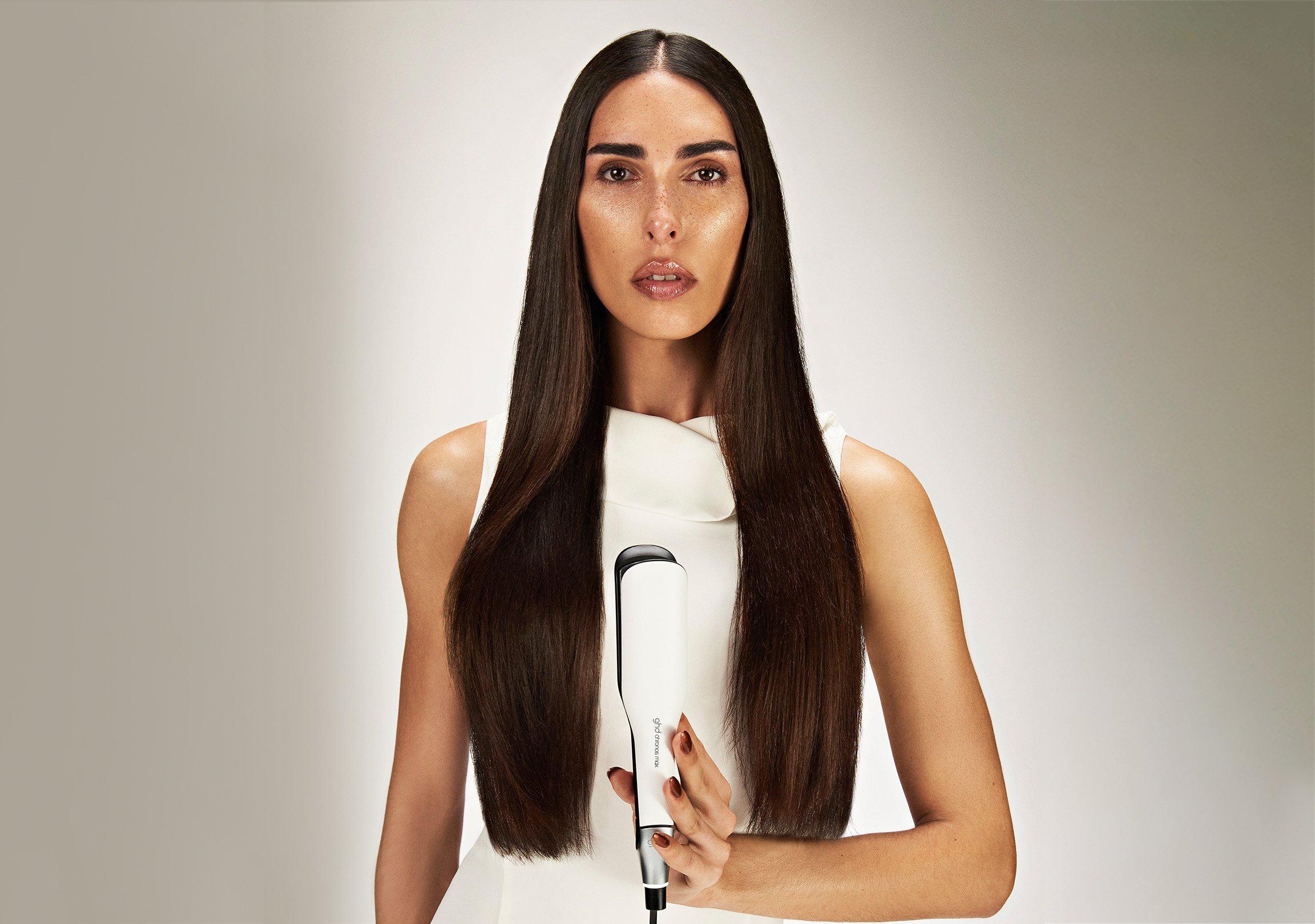 Model präsentiert ghd chronos max mit breiten Stylingplatten