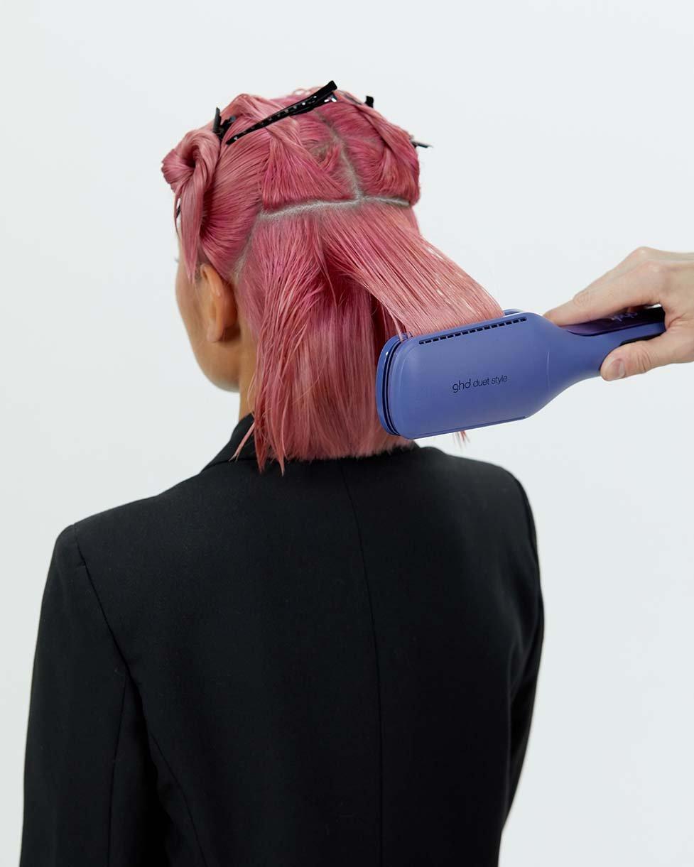 Stylist gleitet mit ghd duet style durch das Haar