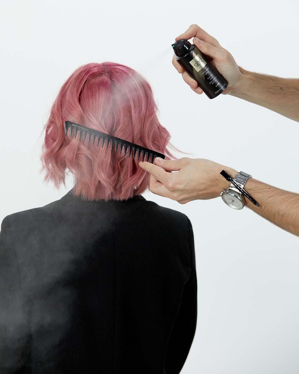 Stylist sprüht ghd Glanzspray auf den ghd detangling comb