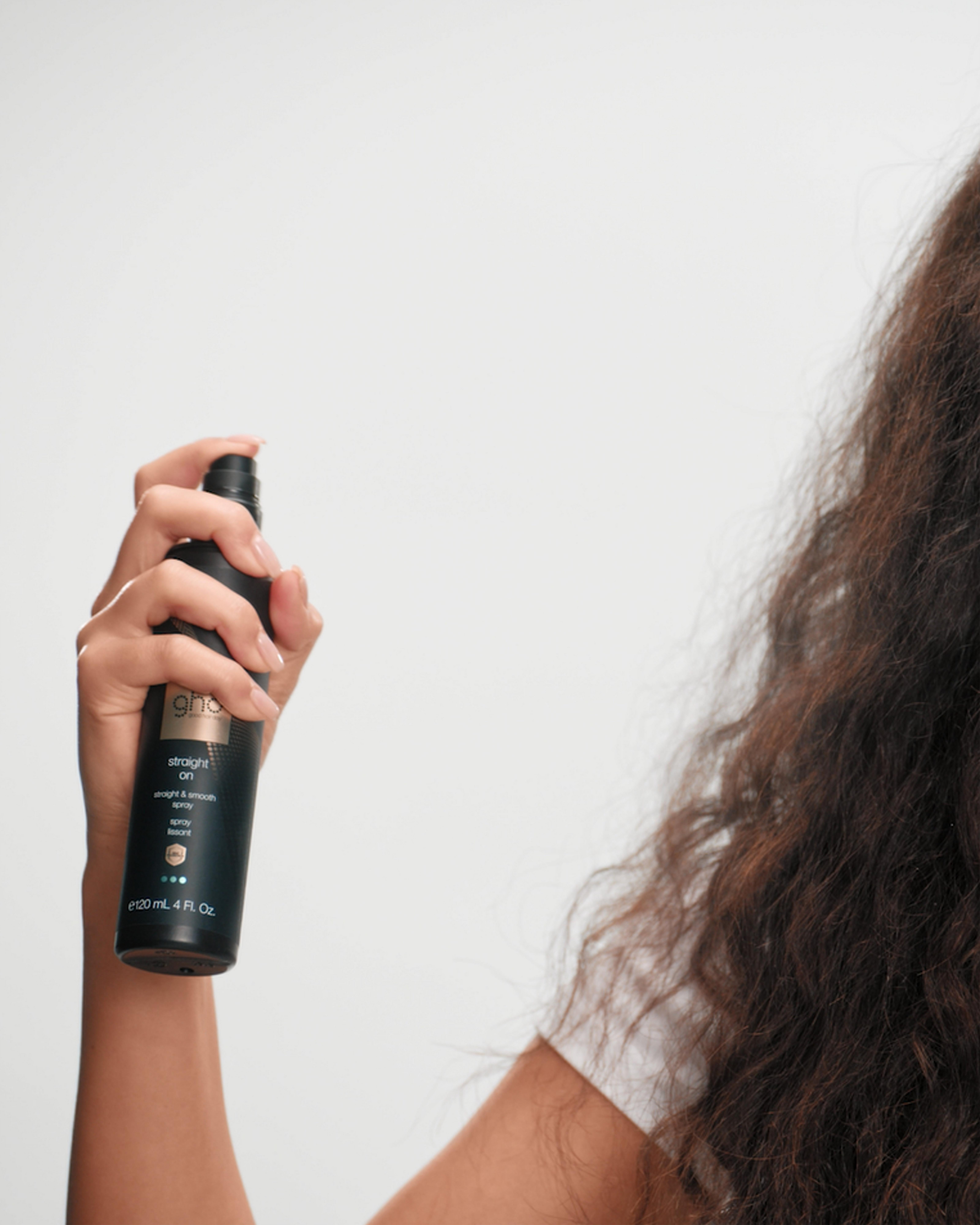 Model misting ghd straight on into their hair