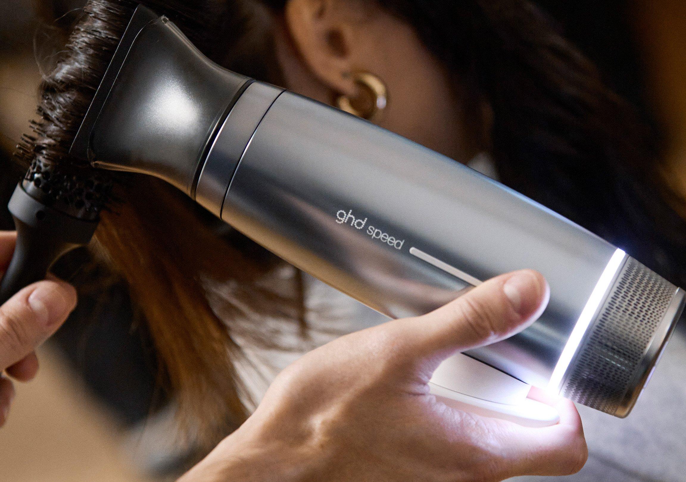 Close up of ghd Speed blow drying hair with a round brush