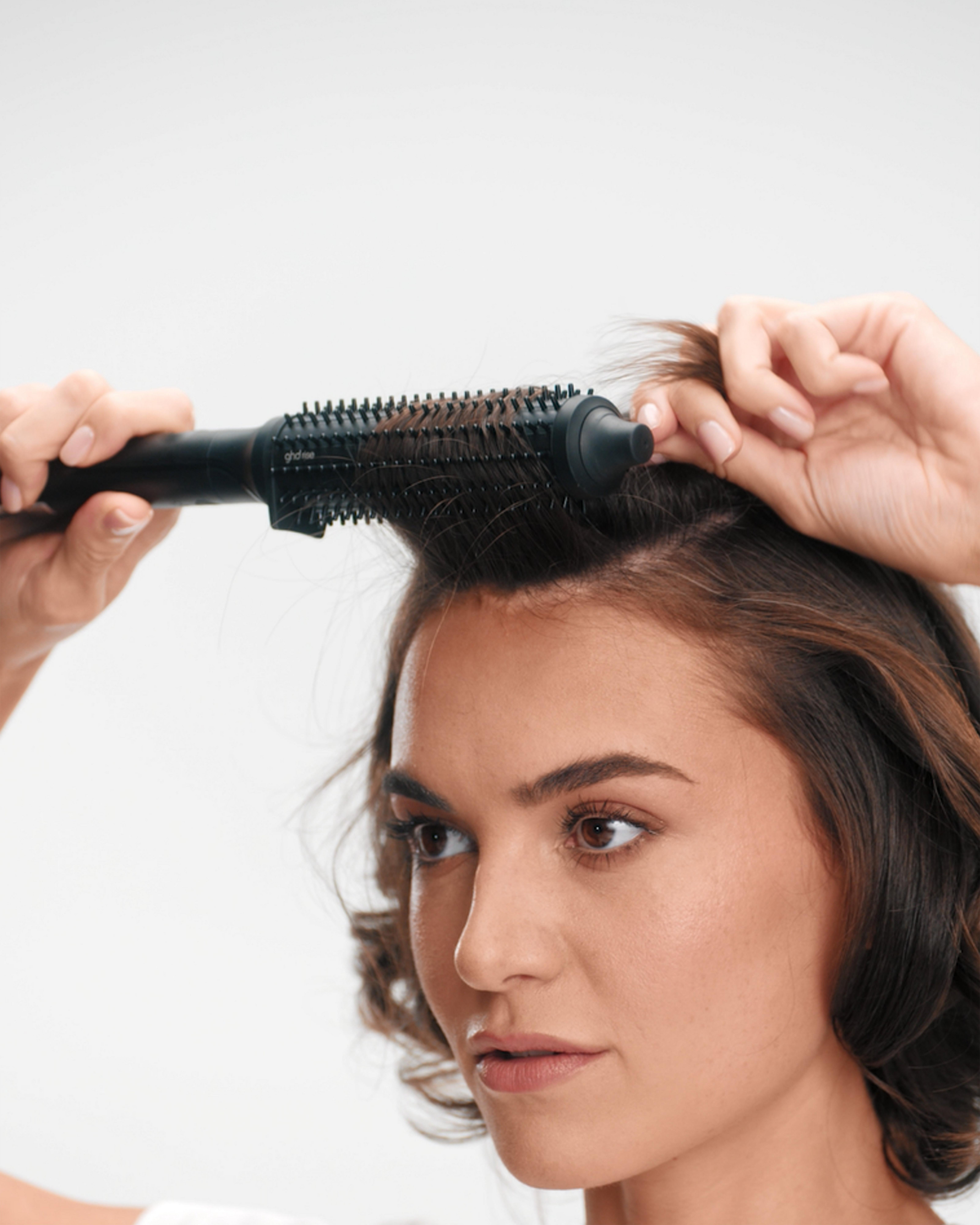 model continuing with each section of her hair, curling away from her face