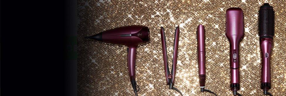 Dunkelrote ghd Stylingtools vor gold glitzerndem Hintergrund